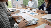 Team reviewing charts and compliance data at a meeting table