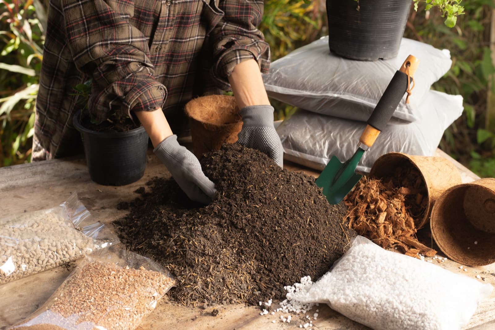 Hands blending premium living soil mix with organic amendments